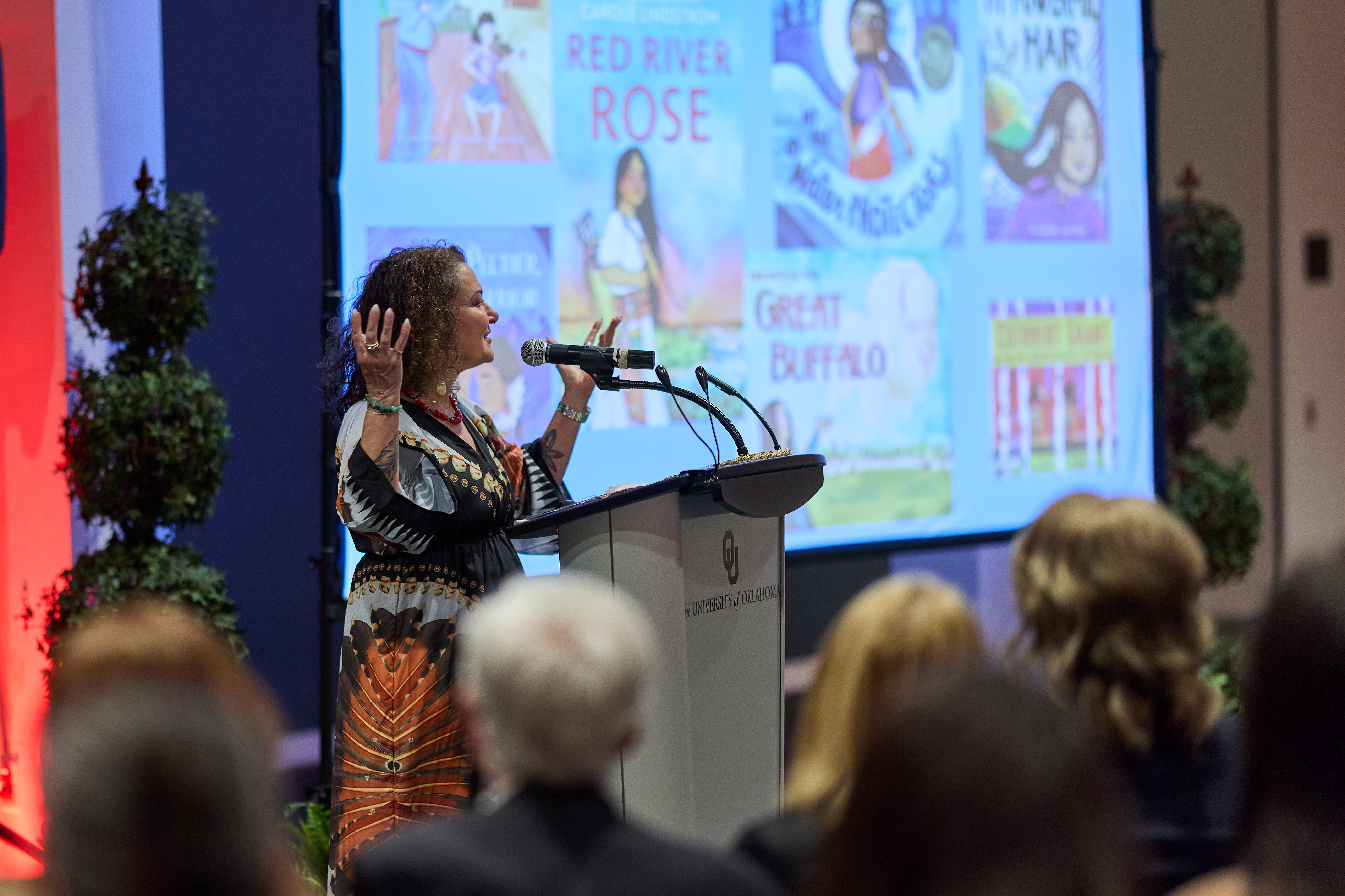 A woman speaking at a microphone.