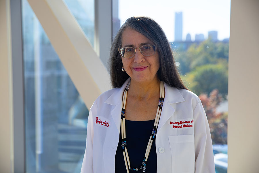 Dorothy Rhoades stands in front of a window while wearing a lab coat.