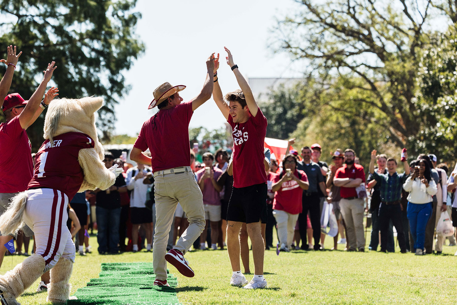 Totzke celebrating with his arms raised in the air. Joseph Harroz lifts his hand for a high five.