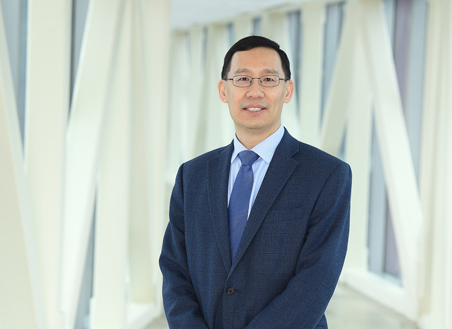 Dr. Min Li posing in an office.