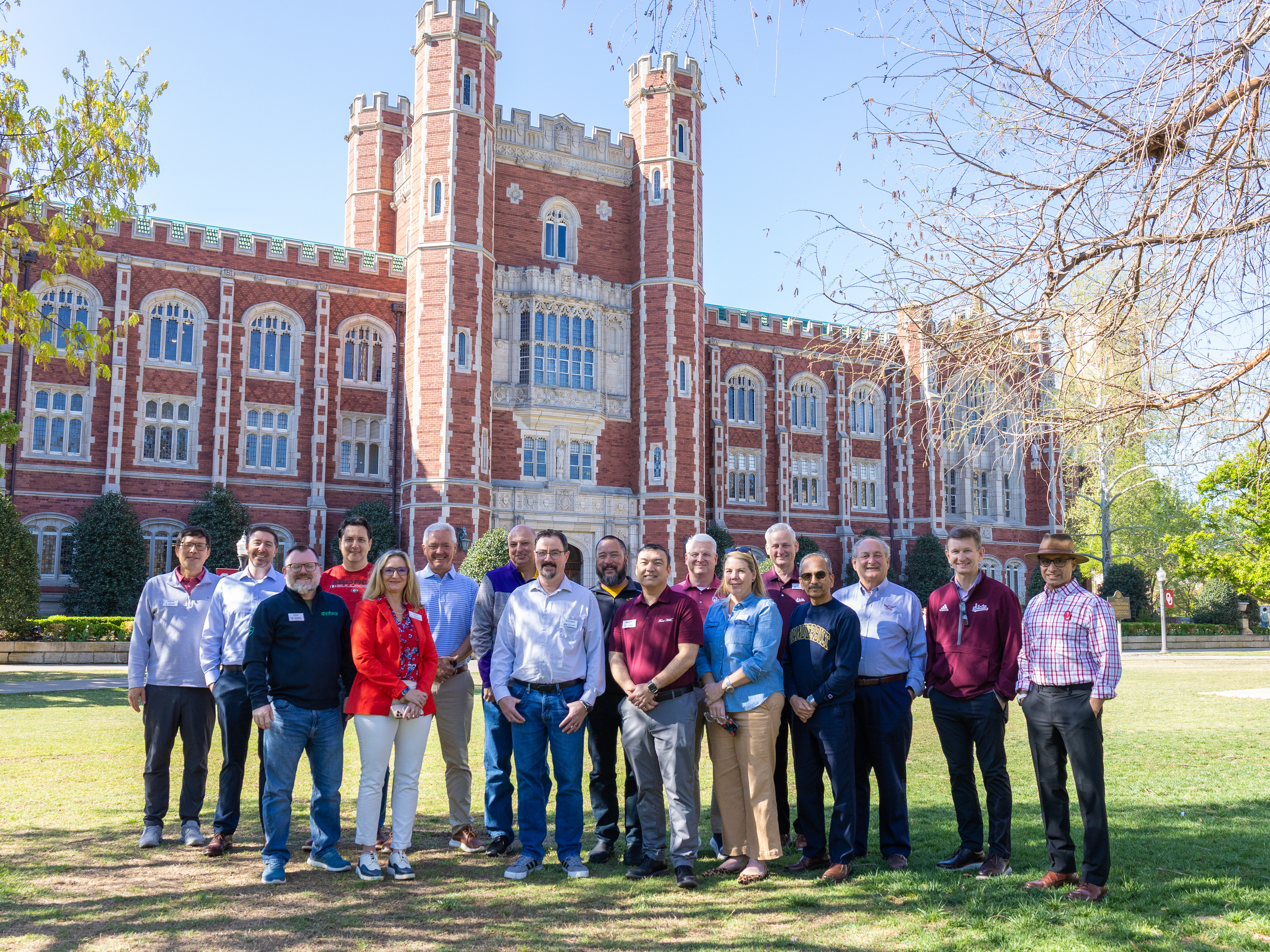 Group of people standing for photo in front of building.