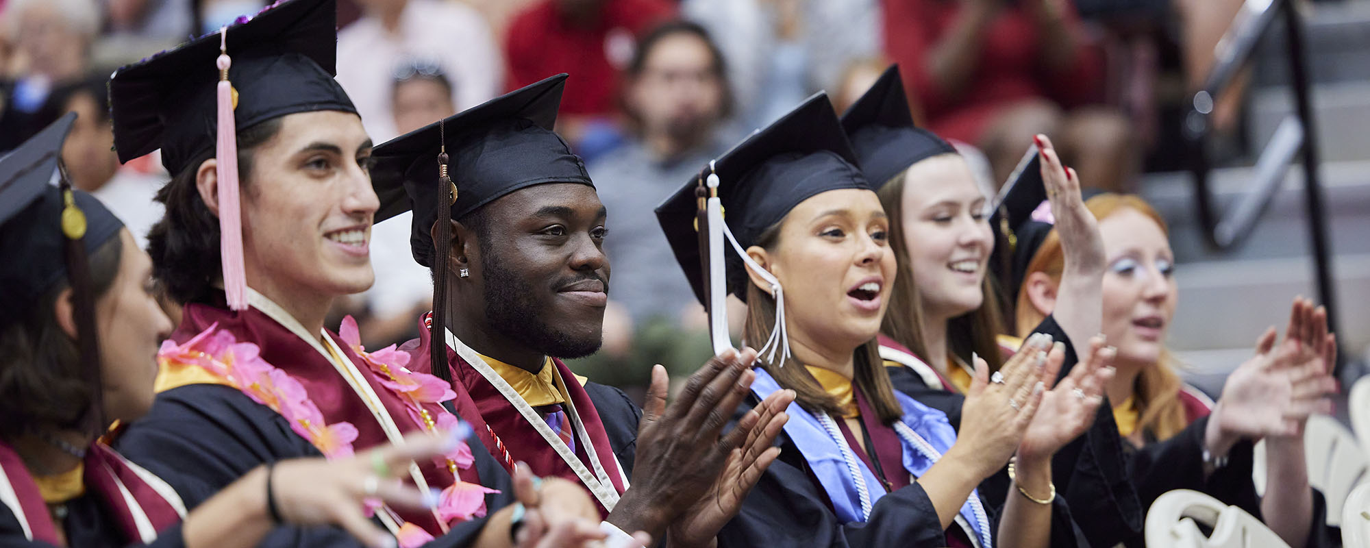 smiling OU graduates celebrating during college graduation ceremony