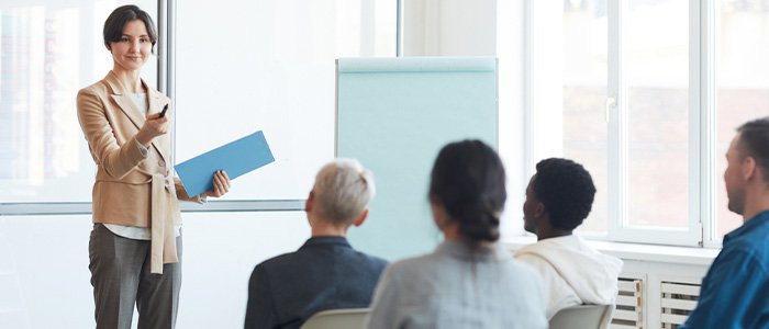 young female executive presenting to coworkers