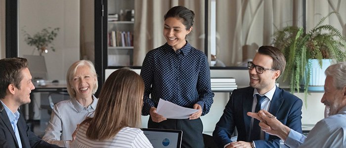 young professional woman giving a presentation to co-workers