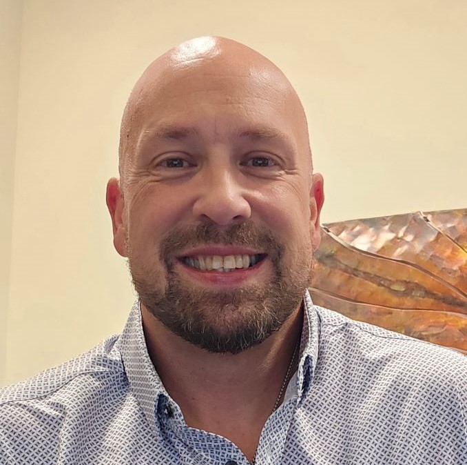 A white person silhouette icon over a crimson background.