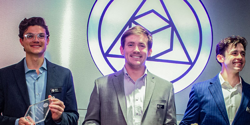 A group of 3 male entrepreneurs celebrating a win at a student competition
