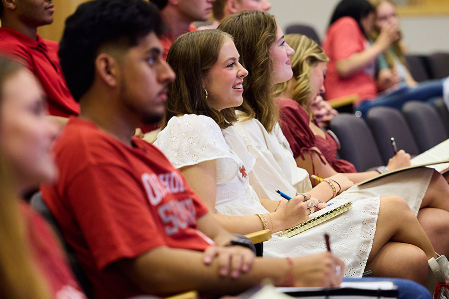 A group of students in OU branded clothing sitting together in a lecture hall.