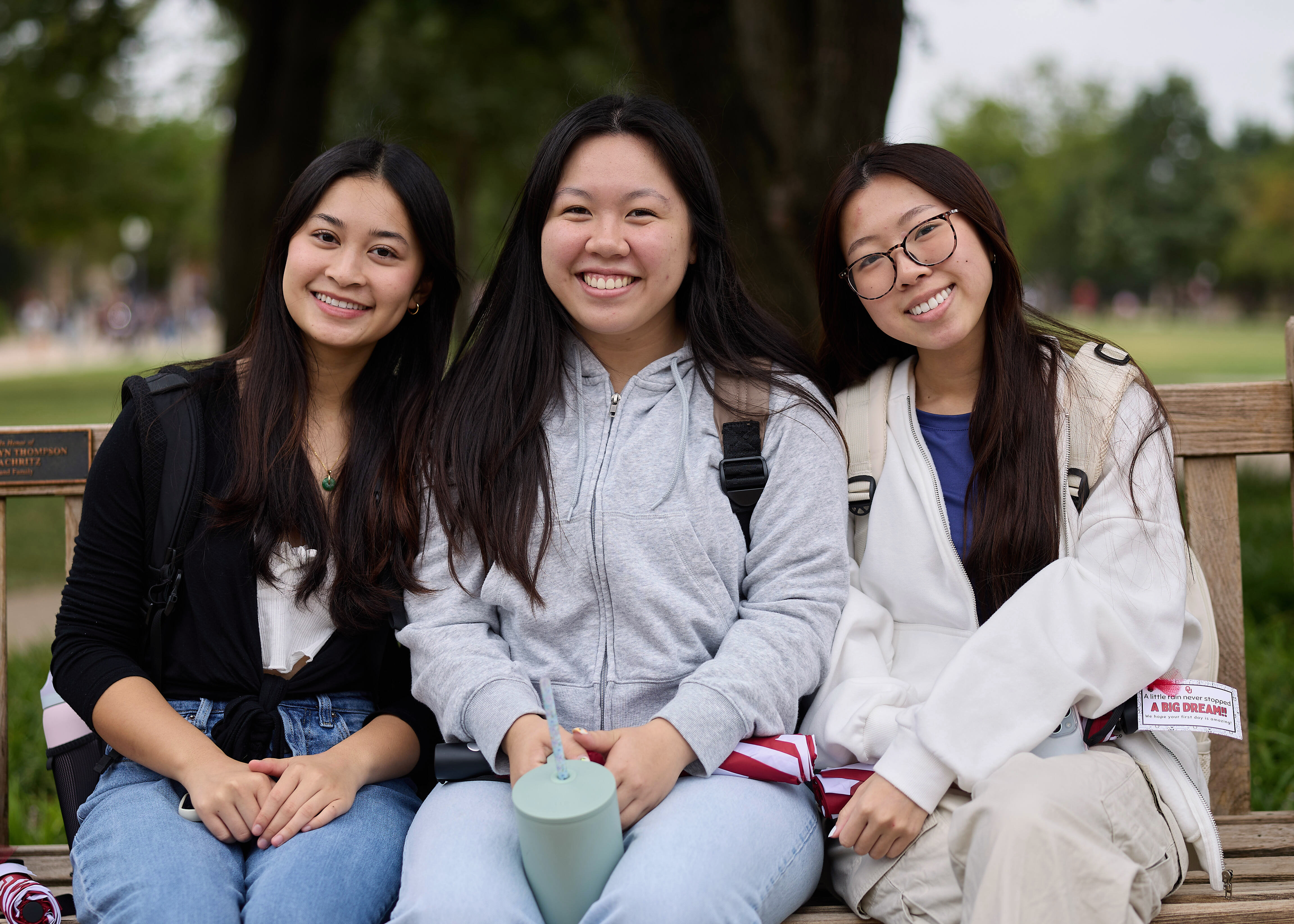 Three students sitting together outside.