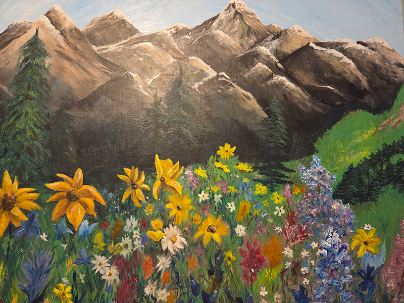 A painting of colorful wildflowers with a large mountain in the background.