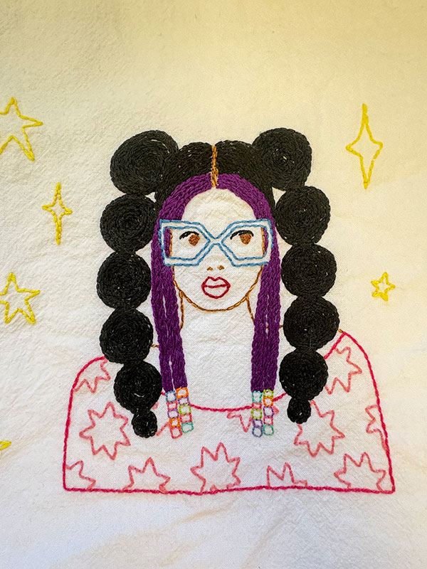 An embroidered figure framed by stars.