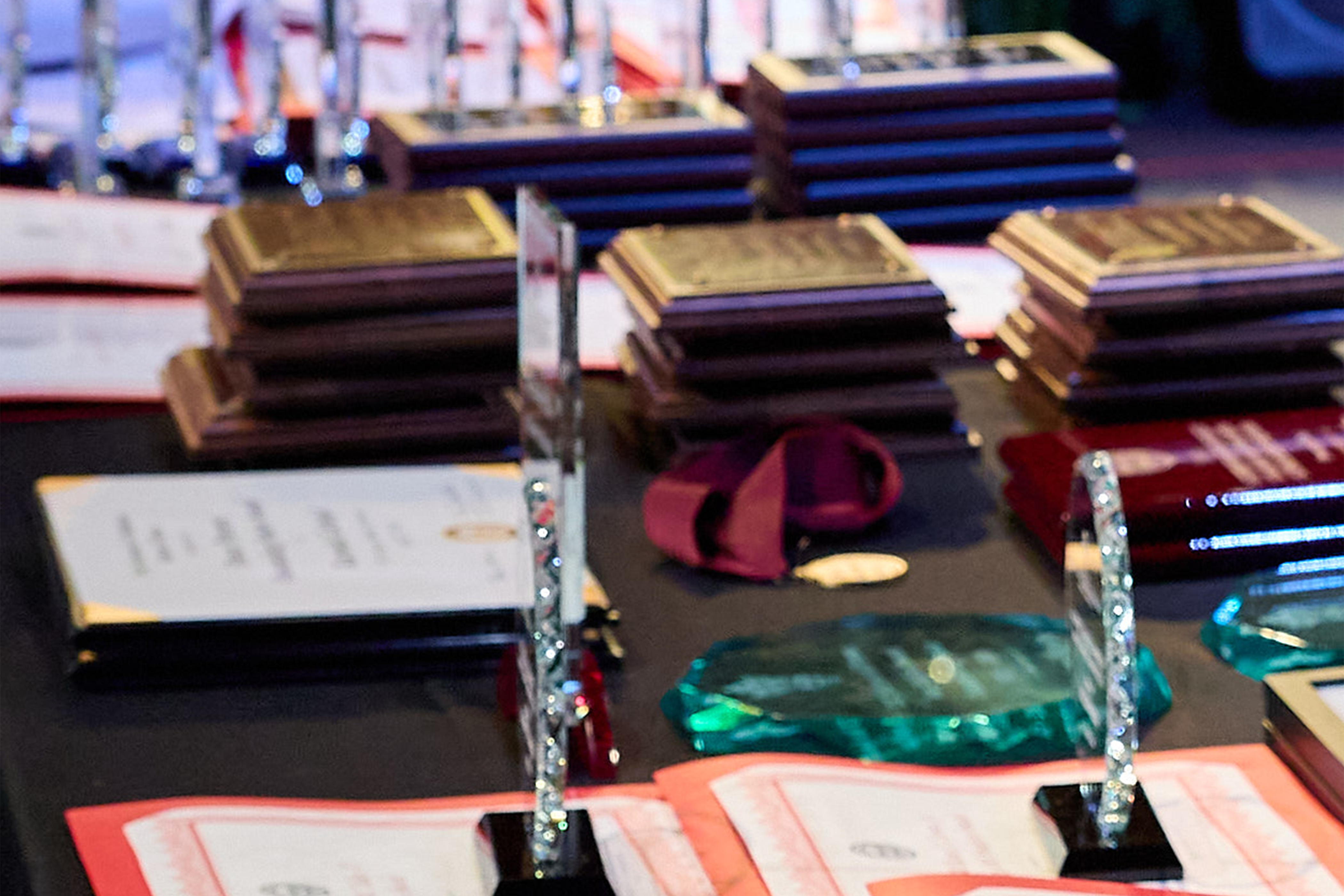 Black table with award certificates and other award items.