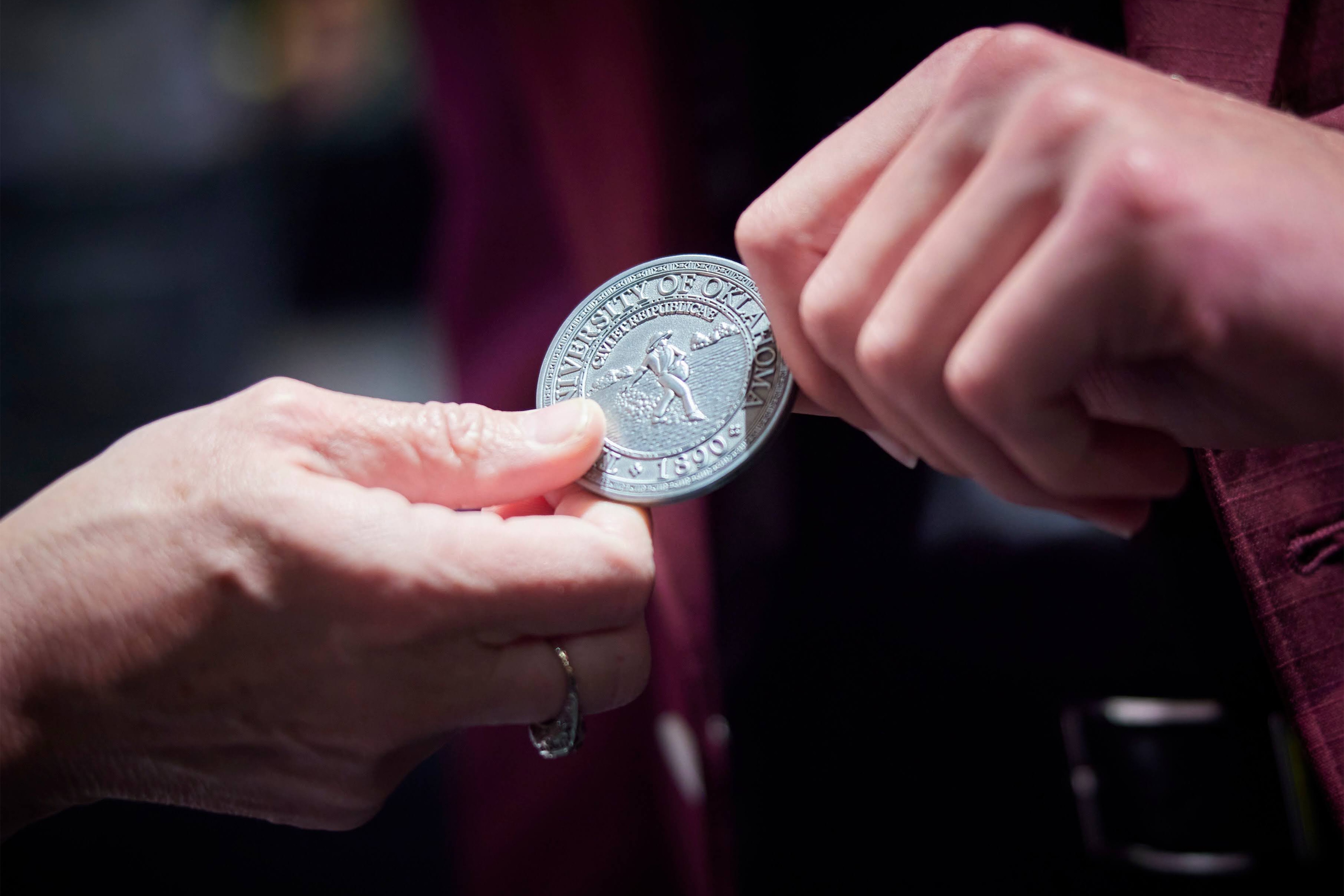 Campus Award medallion being handed off. 
