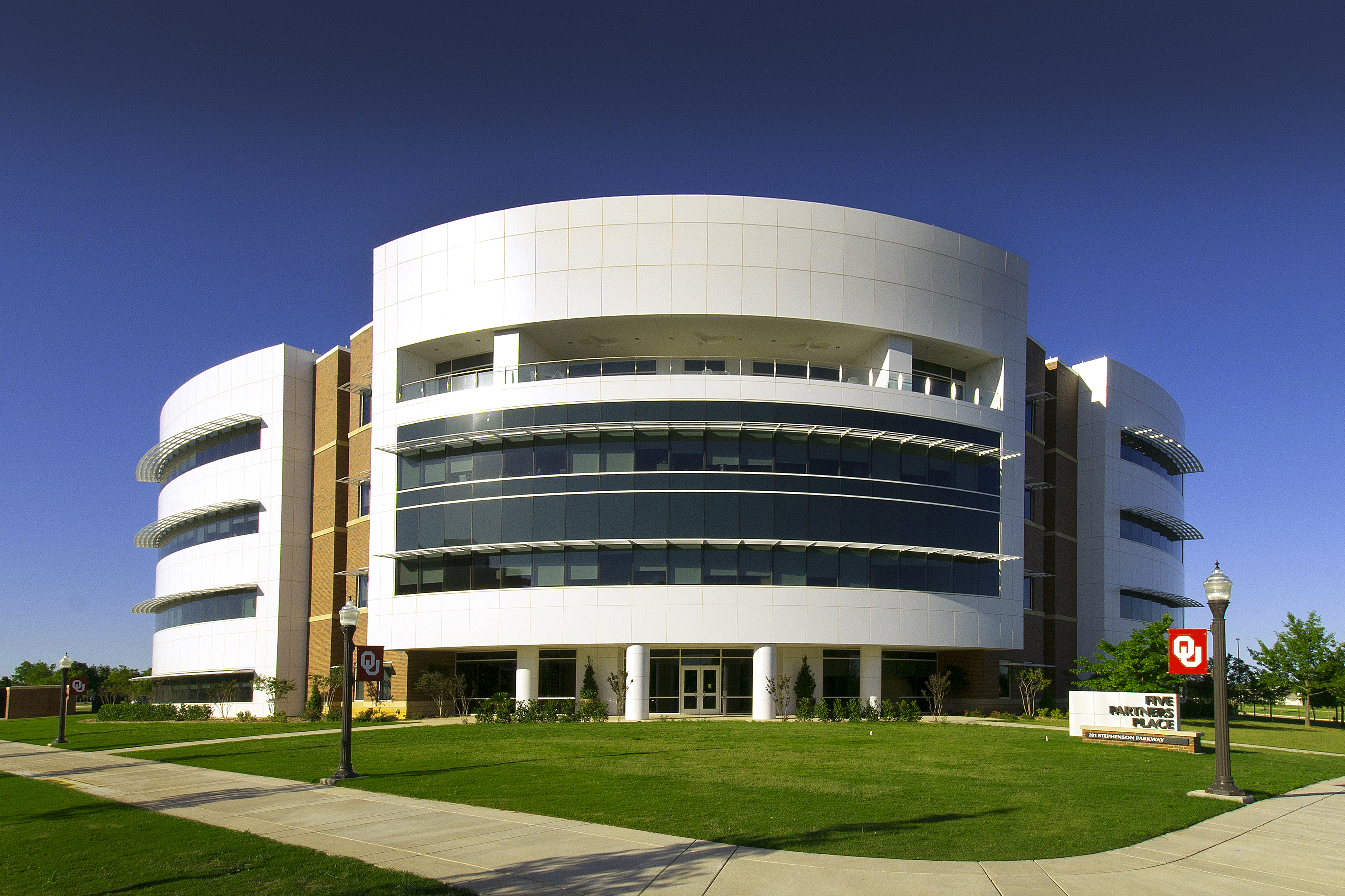Student riding a bicycle in front of the Bizelle library. 